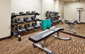 A hotel gym with dumbbells on racks, a bench, and a mirror. - Holiday Inn Express Scottsdale North by IHG (Paradise Valley)