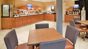 A hotel breakfast area with a self-serve station, seating, and a trash bin. - Holiday Inn Express Scottsdale North by IHG (Paradise Valley)