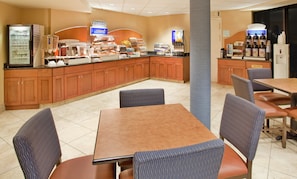 A hotel breakfast area with a self-serve station, seating, and a trash bin. - Holiday Inn Express Scottsdale North by IHG (Paradise Valley)