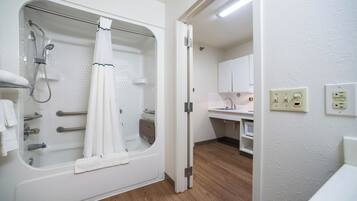 A bathroom with a bathtub, shower, and a sink.