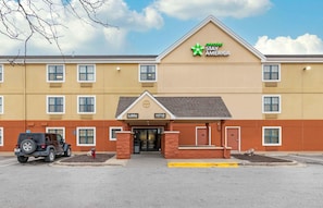 Un hotel amb façana groga, logotip verd i un rètol que indica una recepció al número 11712.