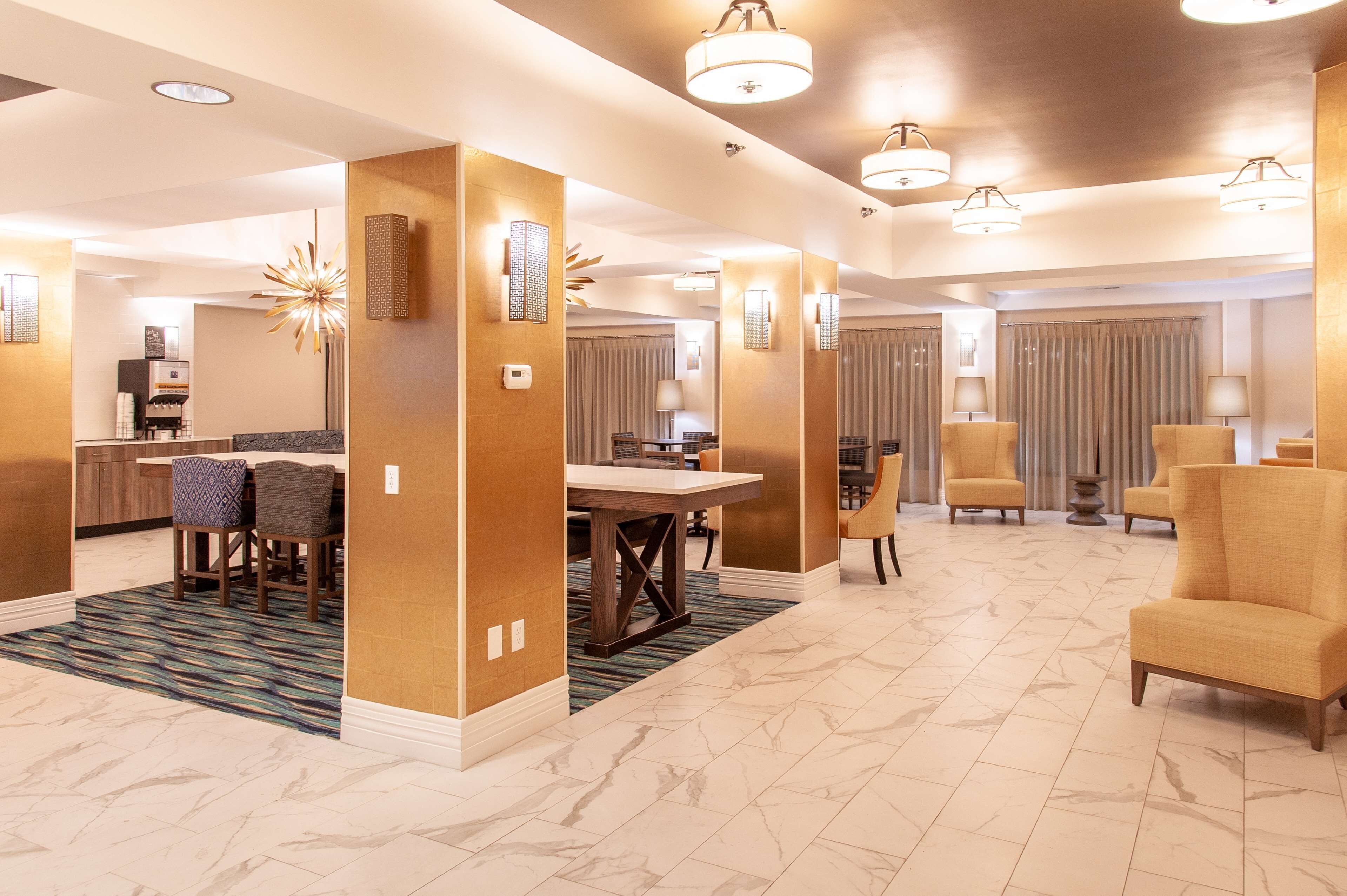 Un hall d’hôtel comprenant un espace repas, des sièges et un comptoir d’accueil.