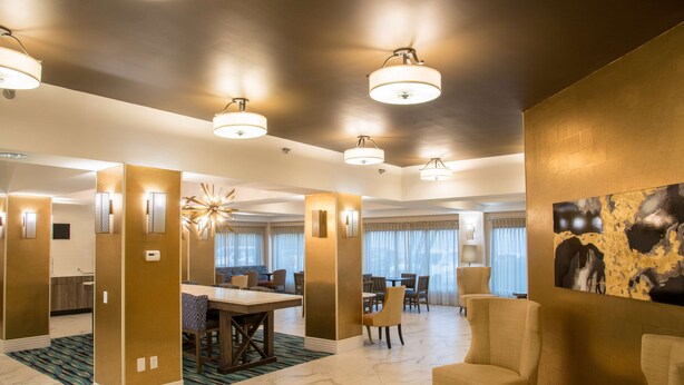 A spacious lobby with a marble floor, a dining area, and a seating area with armchairs and a round table. - Hampton Inn & Suites Jackson-Coliseum (Jackson)