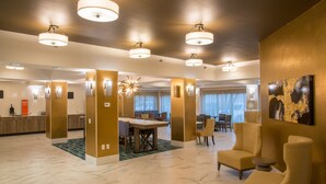 A spacious hotel lobby with a marble floor, a reception desk, a dining area, and several seating options. - Hampton Inn & Suites Jackson-Coliseum (Jackson)