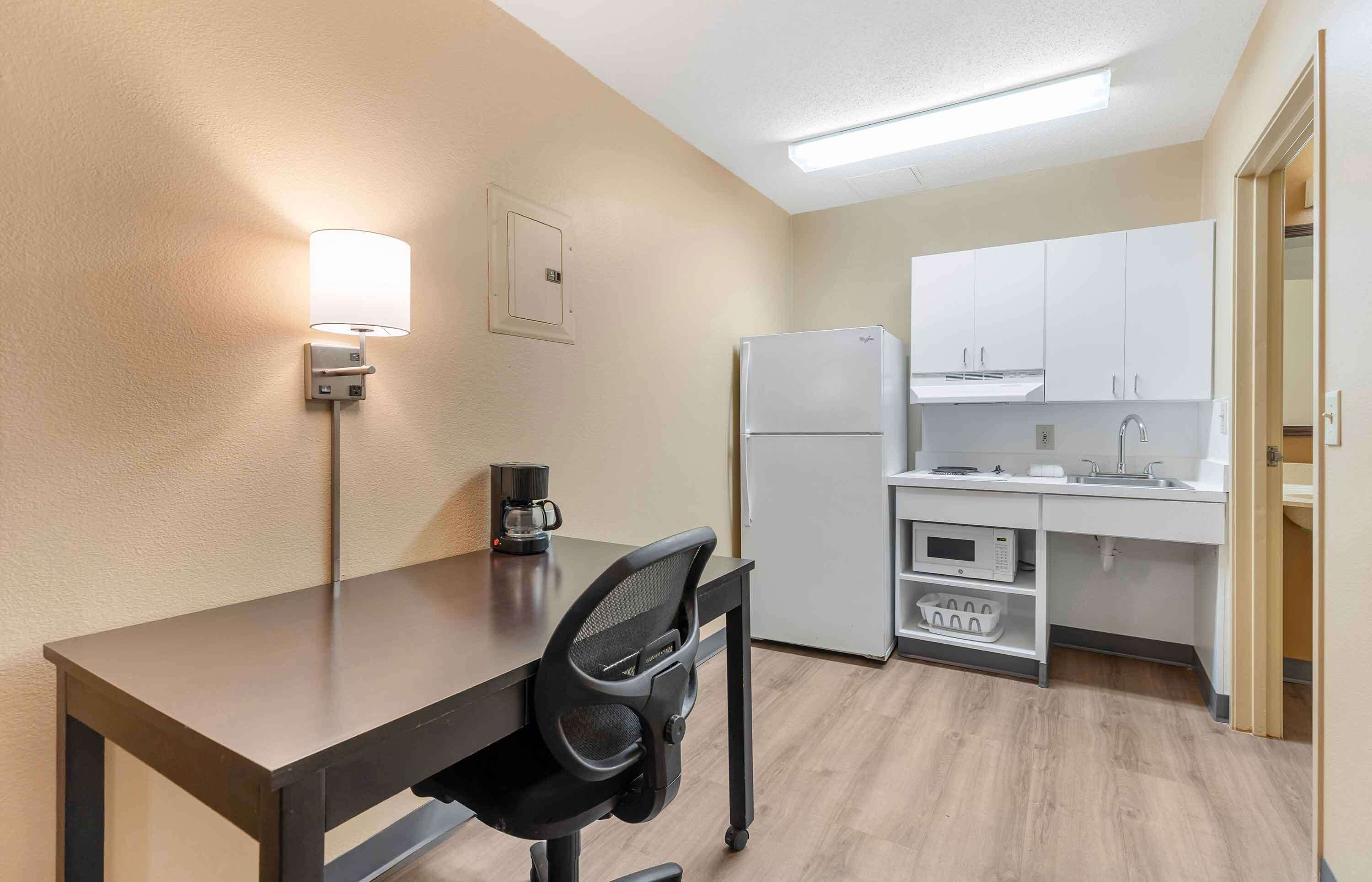 A compact kitchenette with a refrigerator, microwave, and sink.