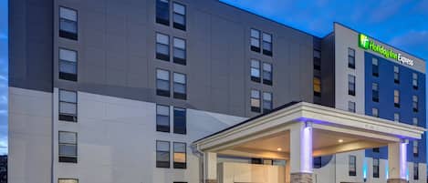 A Holiday Inn Express building with a covered entrance, multiple windows, and a sign indicating the name.