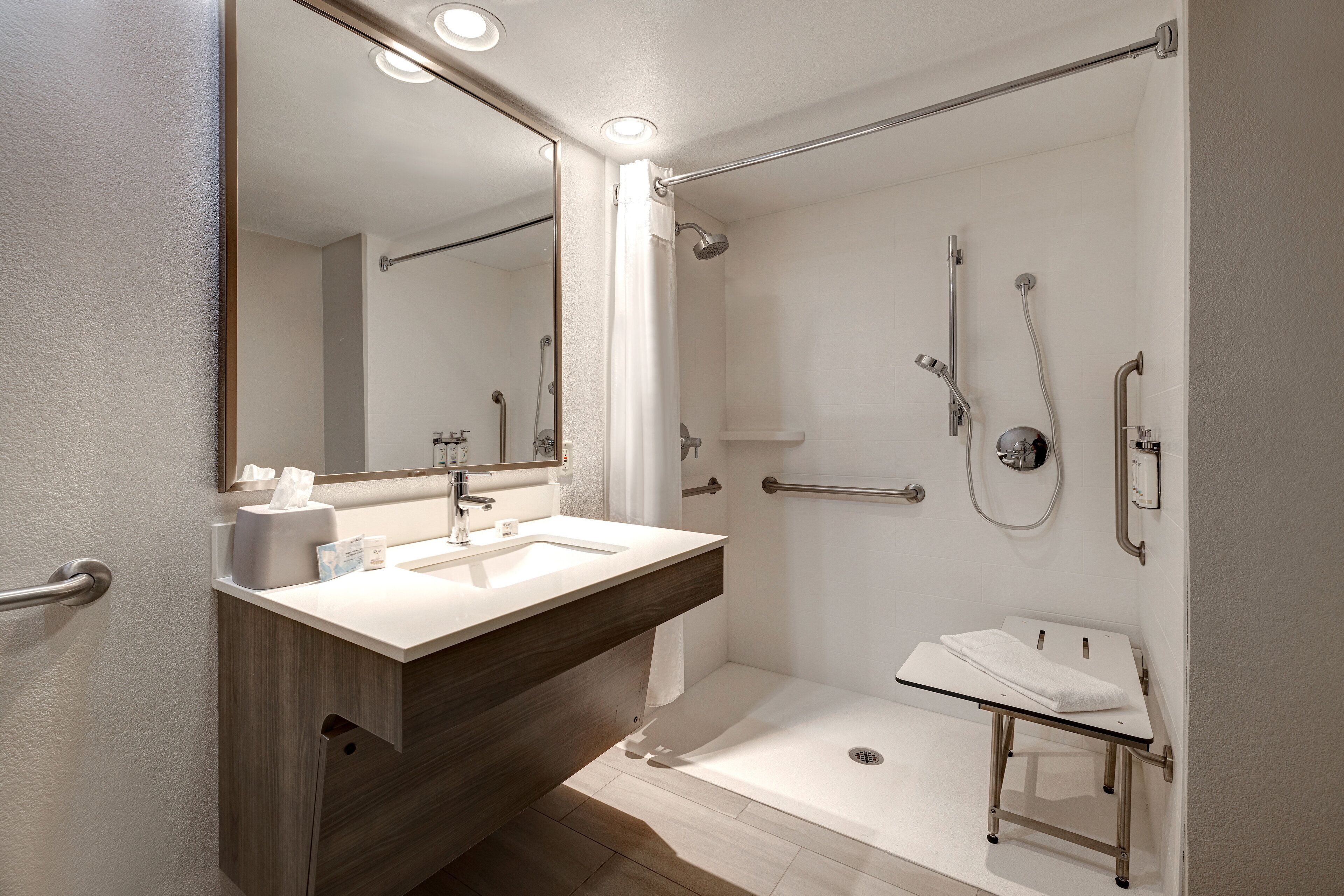 Une salle de bain moderne équipée d’une douche, d’un lavabo et d’un meuble-lavabo.