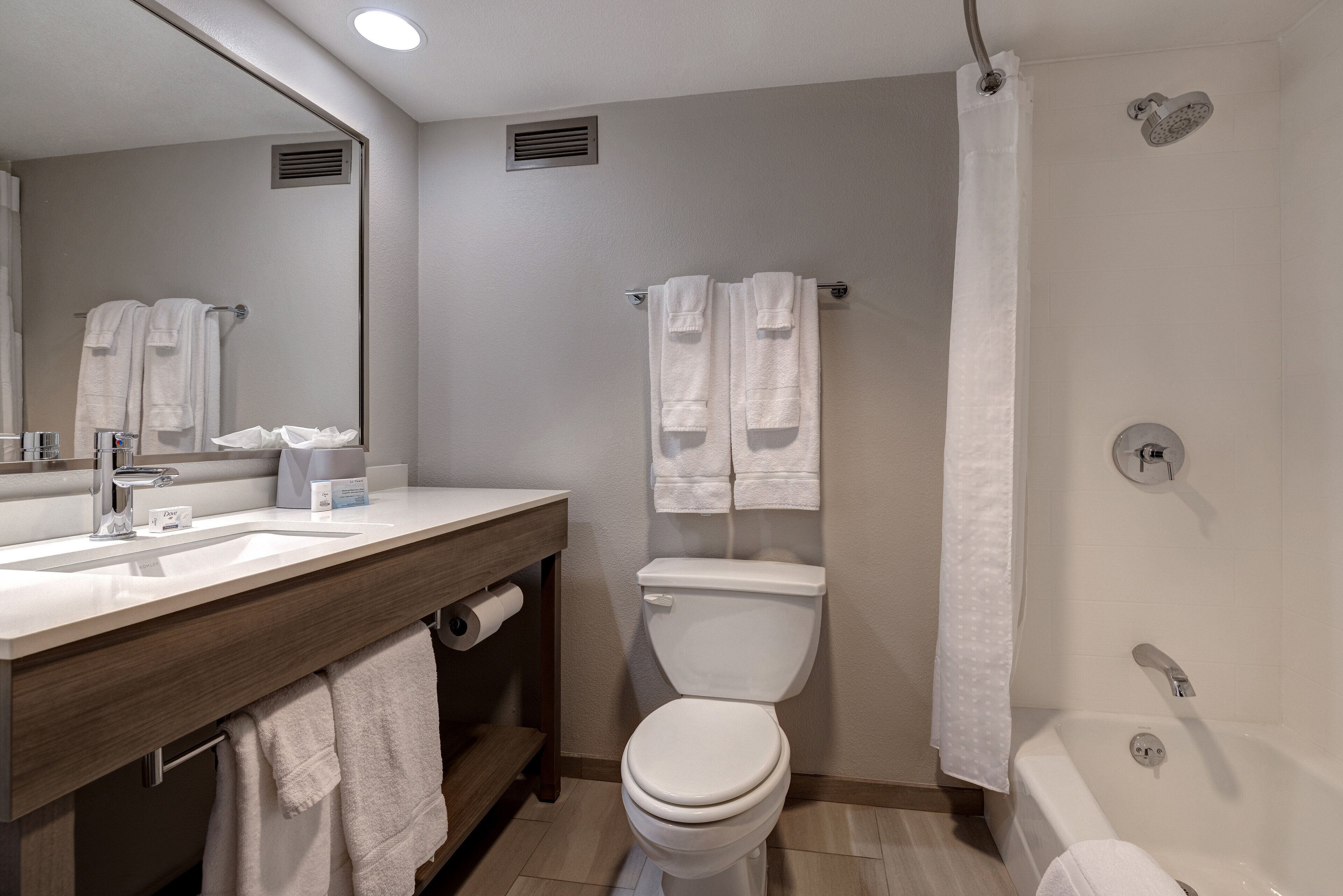 A modern bathroom with a sink, toilet, and bathtub.