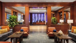 A lobby with a reception desk, seating area, and plants. - Renaissance Columbus Downtown Hotel (Columbus)