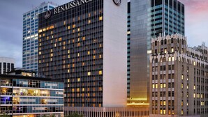 A Renaissance hotel with a modern glass facade, adjacent to a historic building with ornate architecture. - Renaissance Columbus Downtown Hotel (Columbus)
