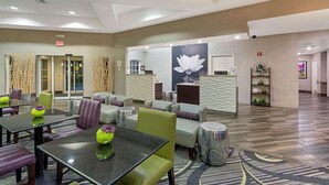 A hotel lobby with a reception desk, seating area, and a large wall mural. - La Quinta Inn & Suites by Wyndham Phoenix Scottsdale (Scottsdale)