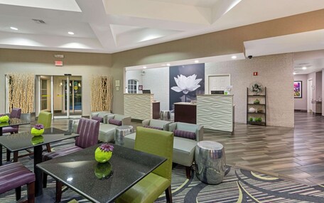 A hotel lobby with a reception desk, seating area, and a large wall mural.