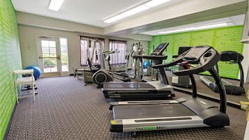 A hotel fitness center with treadmills, elliptical machines, and exercise balls.