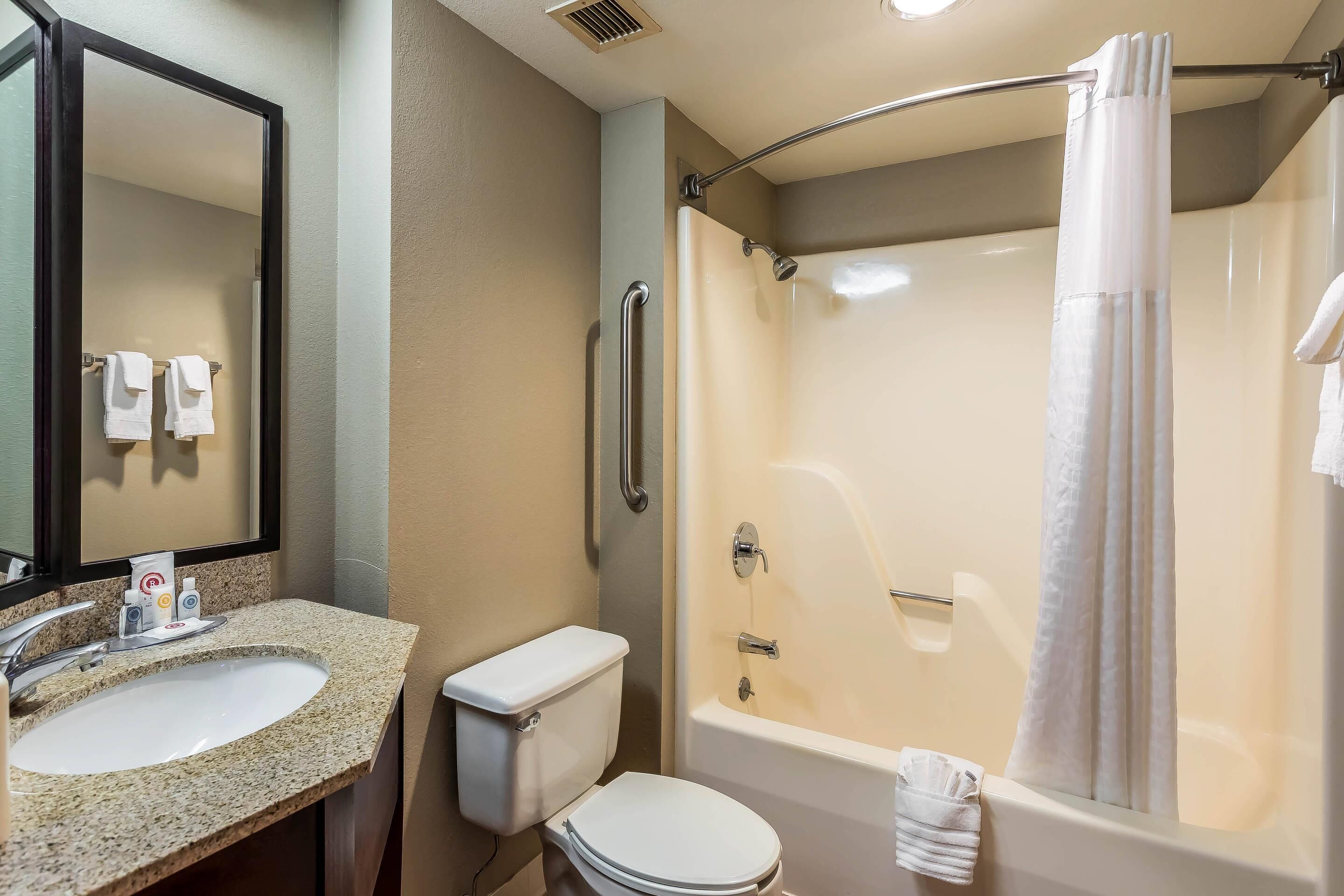 A bathroom with a sink, toilet, and bathtub.