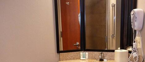 A bathroom with a toilet, sink, and mirror.