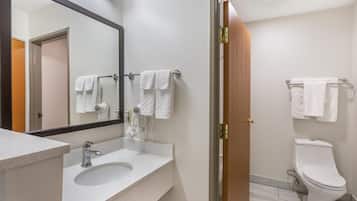 A bathroom with a sink, mirror, towel rack, and toilet.