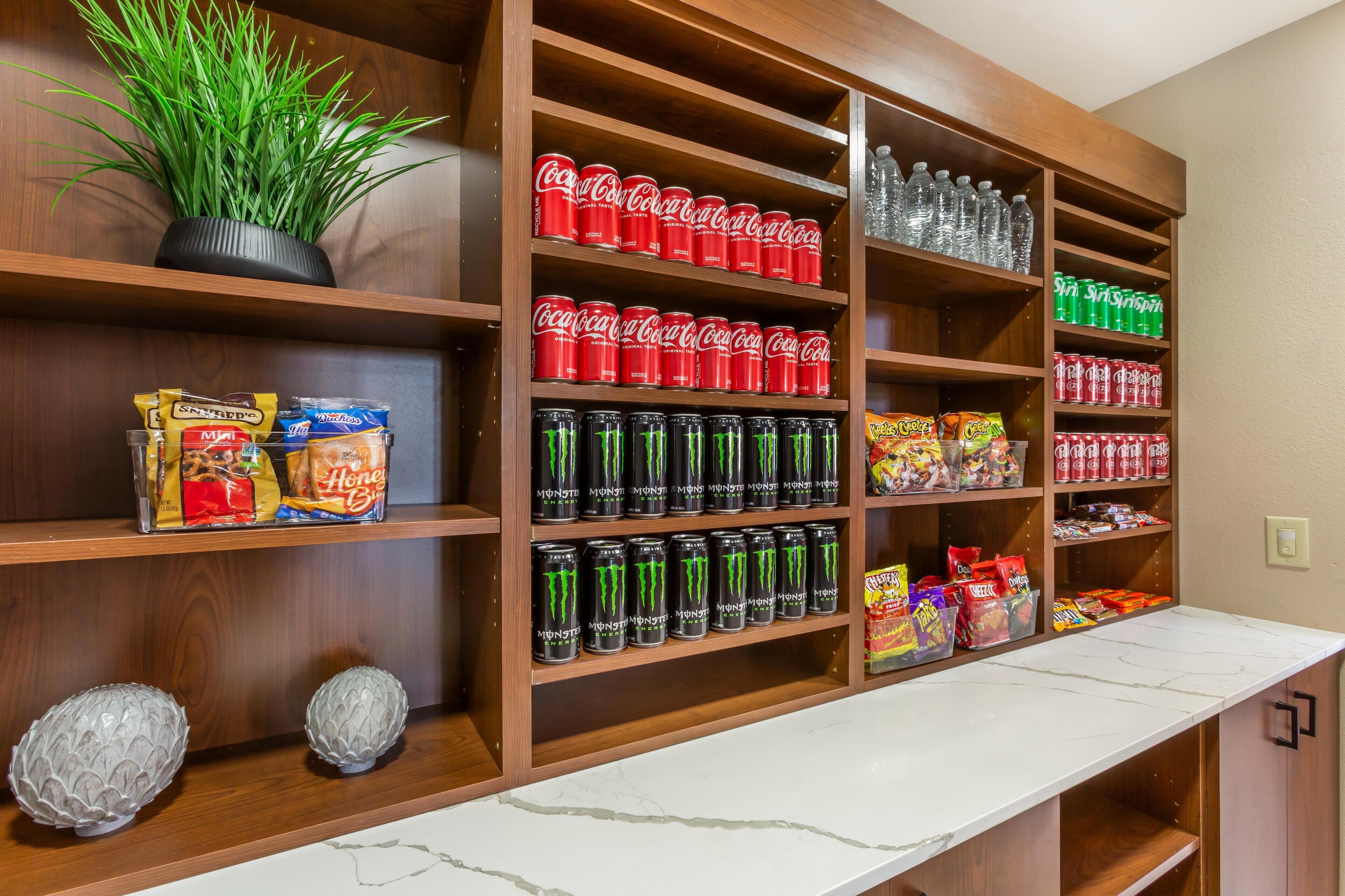 Un área bien organizada para almacenar bebidas y aperitivos, con estantes llenos de diversas opciones.