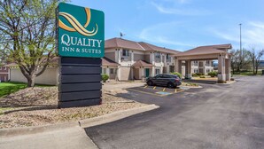 A Quality Inn & Suites with a signboard, a parking lot, and a building with multiple units. - Quality Inn & Suites Omaha Chalco (Omaha)