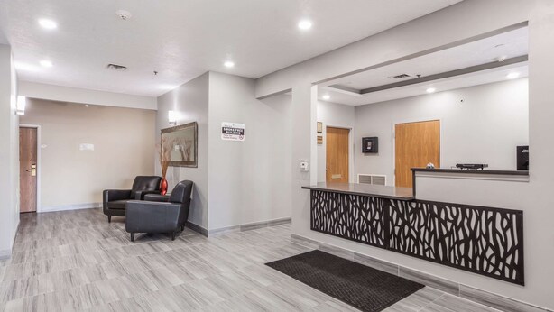 A modern reception area with a reception desk, a waiting area with chairs, and a sign indicating no smoking. - Quality Inn & Suites Omaha Chalco (Omaha)