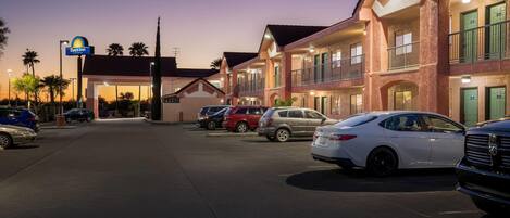 Un hôtel arborant l’enseigne Days Inn, doté de nombreux balcons et d’un parking où sont stationnées plusieurs voitures.