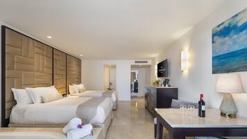 A hotel room with two beds, a sitting area with a table, a large painting, and a TV on the wall.