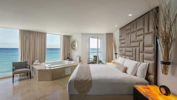 Une chambre d’hôtel moderne avec un grand lit, une baignoire et une vue sur l’océan.