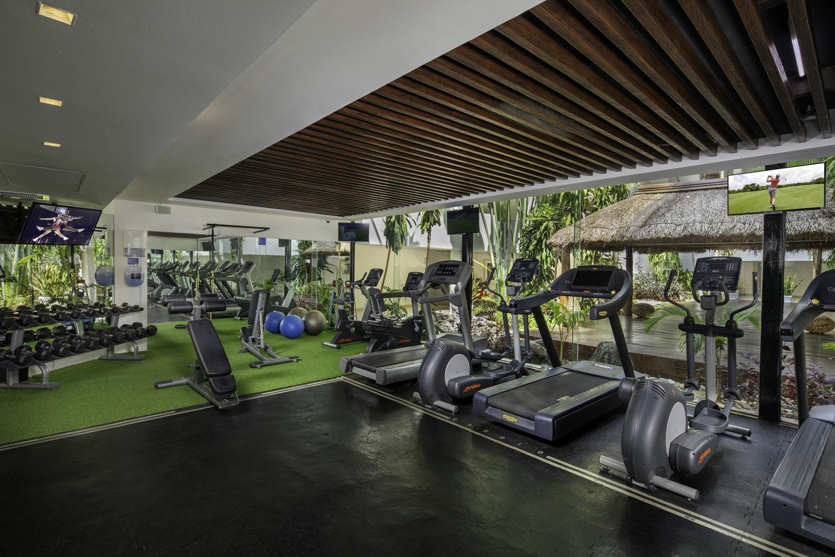A gym with treadmills, elliptical machines, and weight benches.