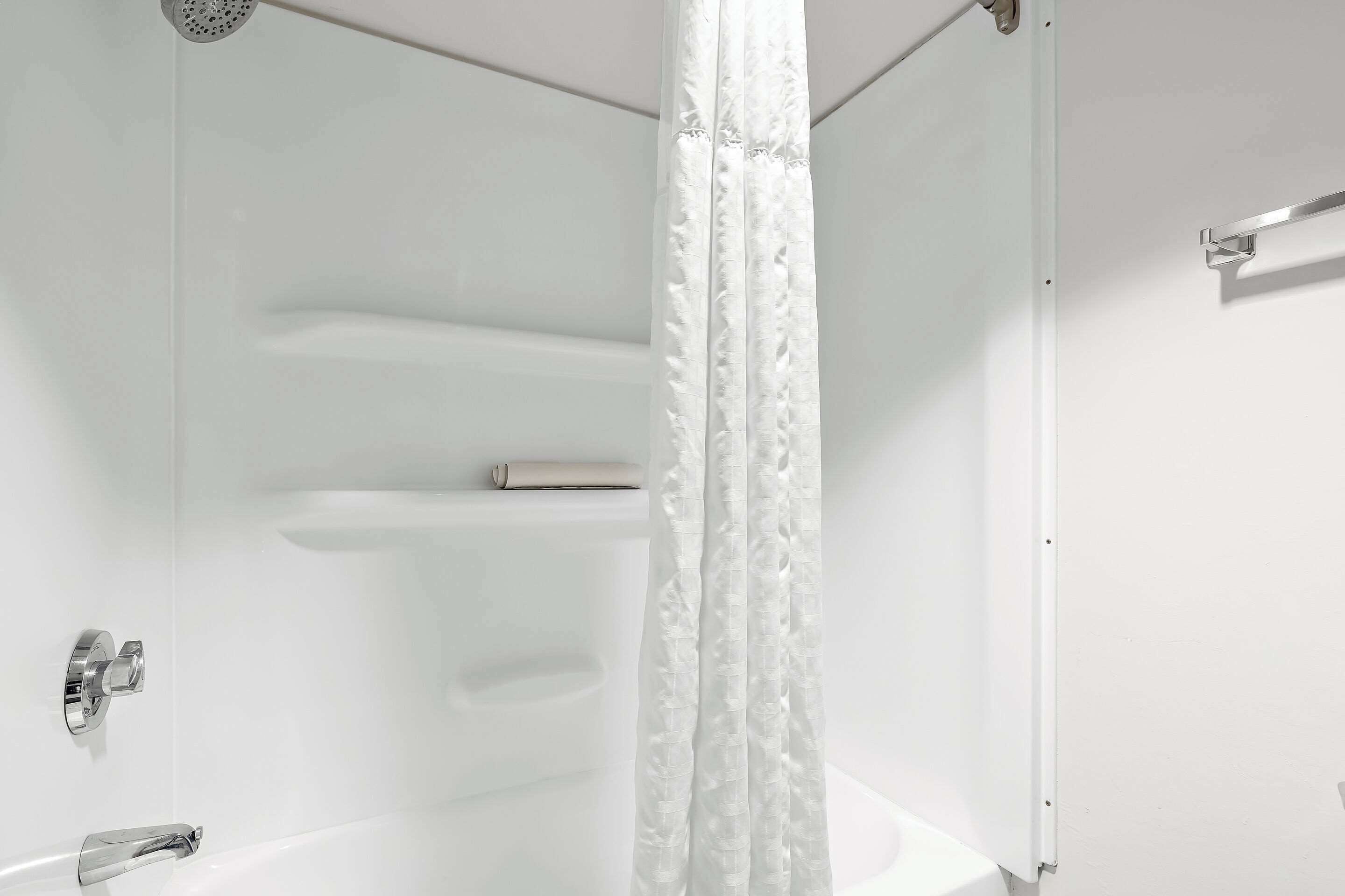 Ein modernes Badezimmer mit einer Badewanne, einer Duschvorhang und einem Handtuchhalter.