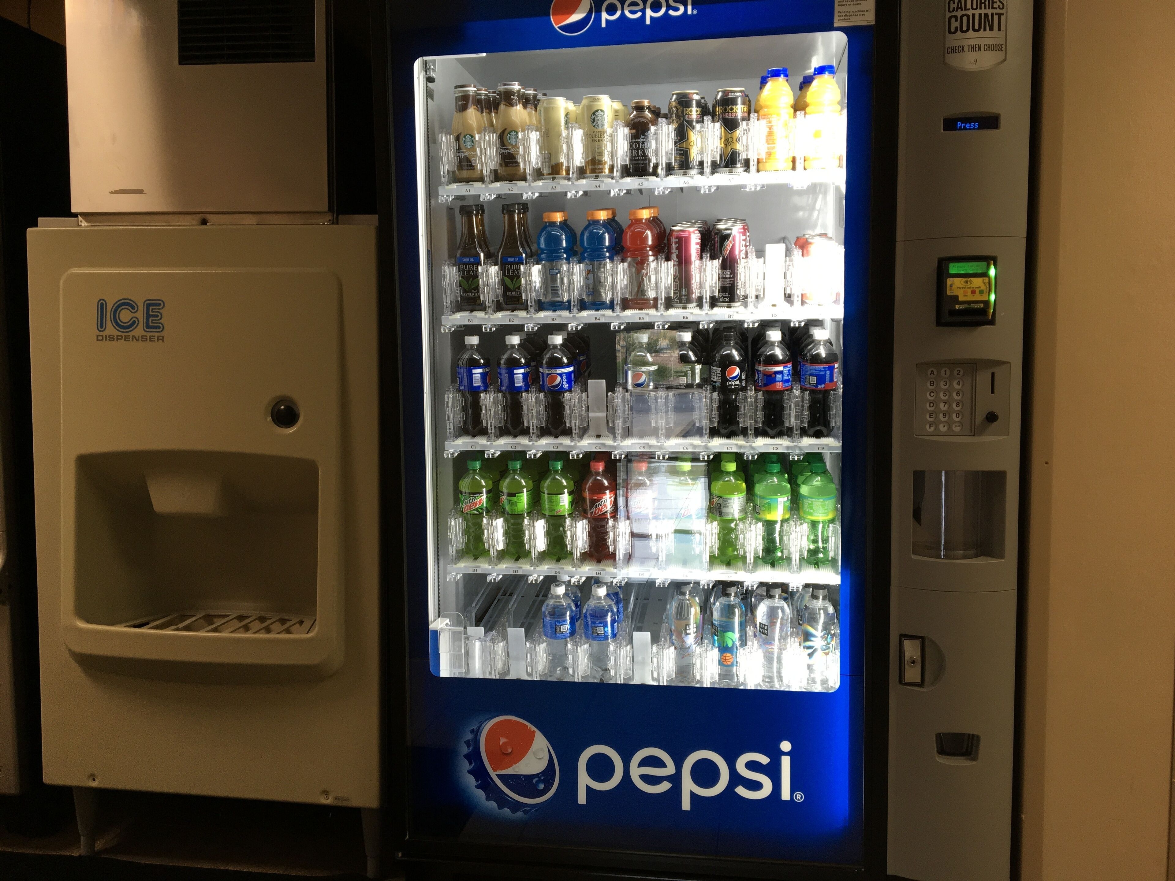 A vending machine stocked with various beverages including Pepsi, water, and sports drinks.