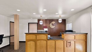 A reception area with a wooden counter, a desk, and a "WELCOME" sign. - Comfort Inn & Suites near Kino Sports Complex (Tucson)