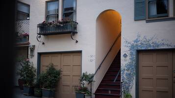 A building with a staircase leading to a second floor, potted plants, and a number '30' on the wall.