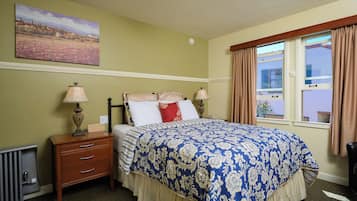 A neatly arranged bedroom with a bed, bedside lamps, a nightstand, and a window with curtains.
