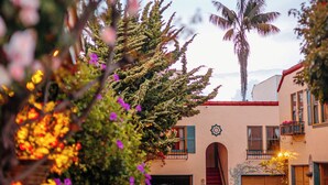 A building with a red door, a staircase, and a palm tree in the background. - Marina Motel (San Francisco)