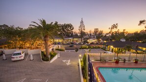 A hotel with a swimming pool, parking area, and outdoor seating. - Coast Village Inn - Santa Barbara (Santa Barbara)