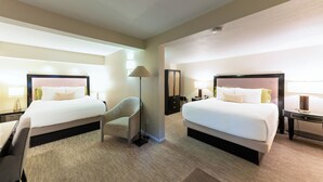 A hotel room with two beds, a desk, a chair, and a lamp. - Coast Village Inn - Santa Barbara (Santa Barbara)