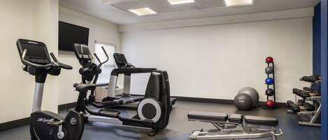 A gym with cardio machines, weightlifting equipment, and exercise balls.