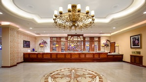 A spacious lobby with a grand chandelier, a reception desk, and a decorative floor pattern. - Gold Coast Hotel and Casino (Las Vegas)