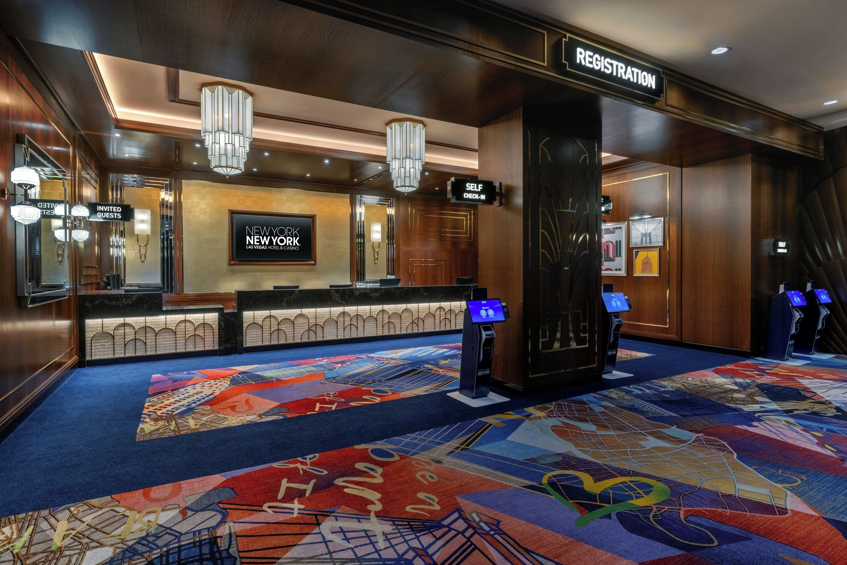 A hotel lobby with a registration desk, self-check-in kiosks, and a reception area.