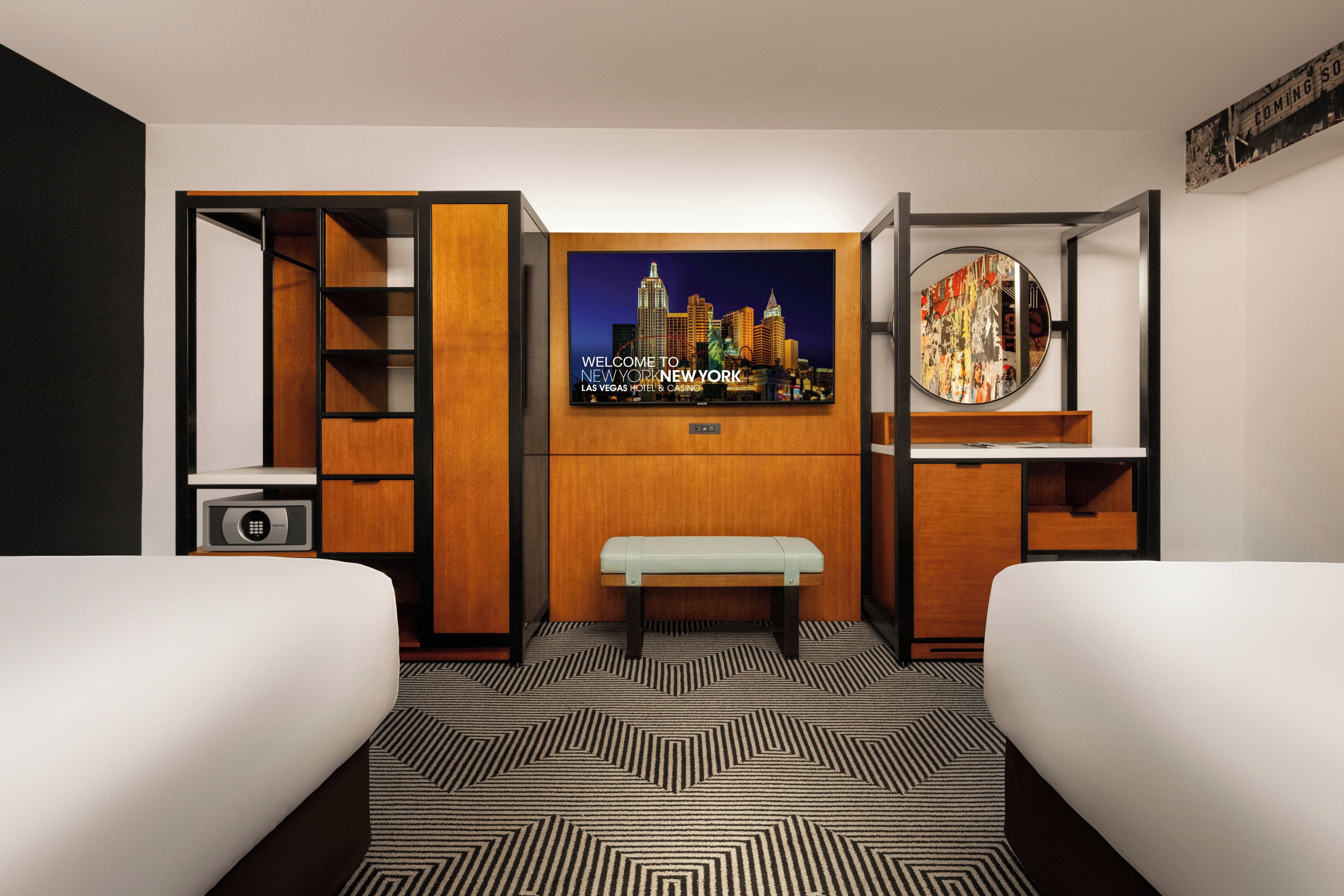 Een hotelkamer met een bed, bureau, stoel, televisie en spiegel.