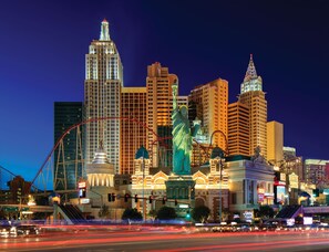 A cityscape with prominent buildings, including a tall skyscraper and the Statue of Liberty. - New York-New York Hotel & Casino (Las Vegas)