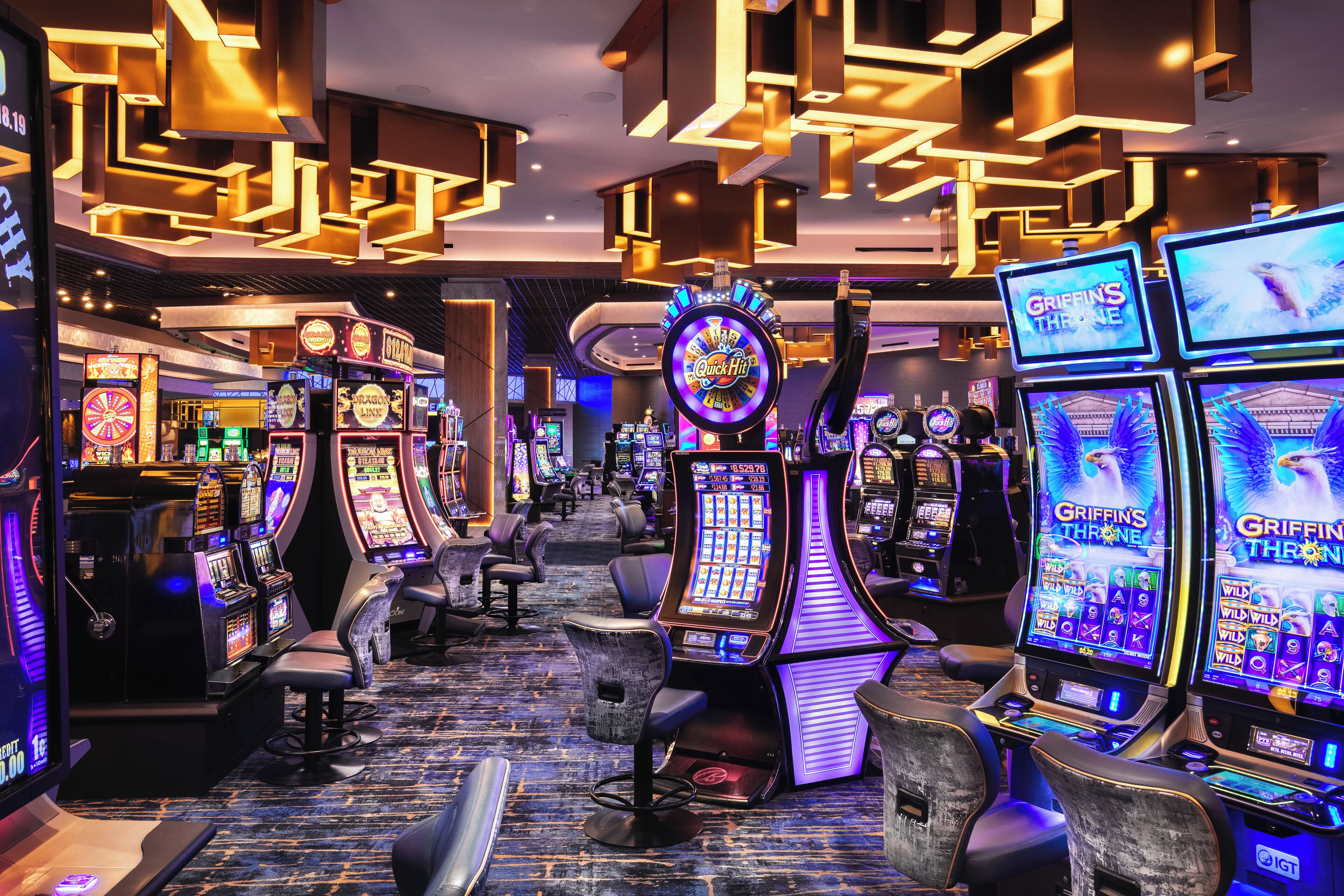 A casino with slot machines, gaming tables, and comfortable seating areas.