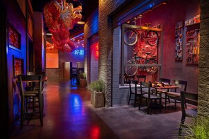 A restaurant with a narrow, dimly lit corridor, wooden chairs, tables, and a bicycle display.