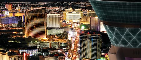 A nighttime cityscape with illuminated buildings and a view of the Las Vegas skyline.