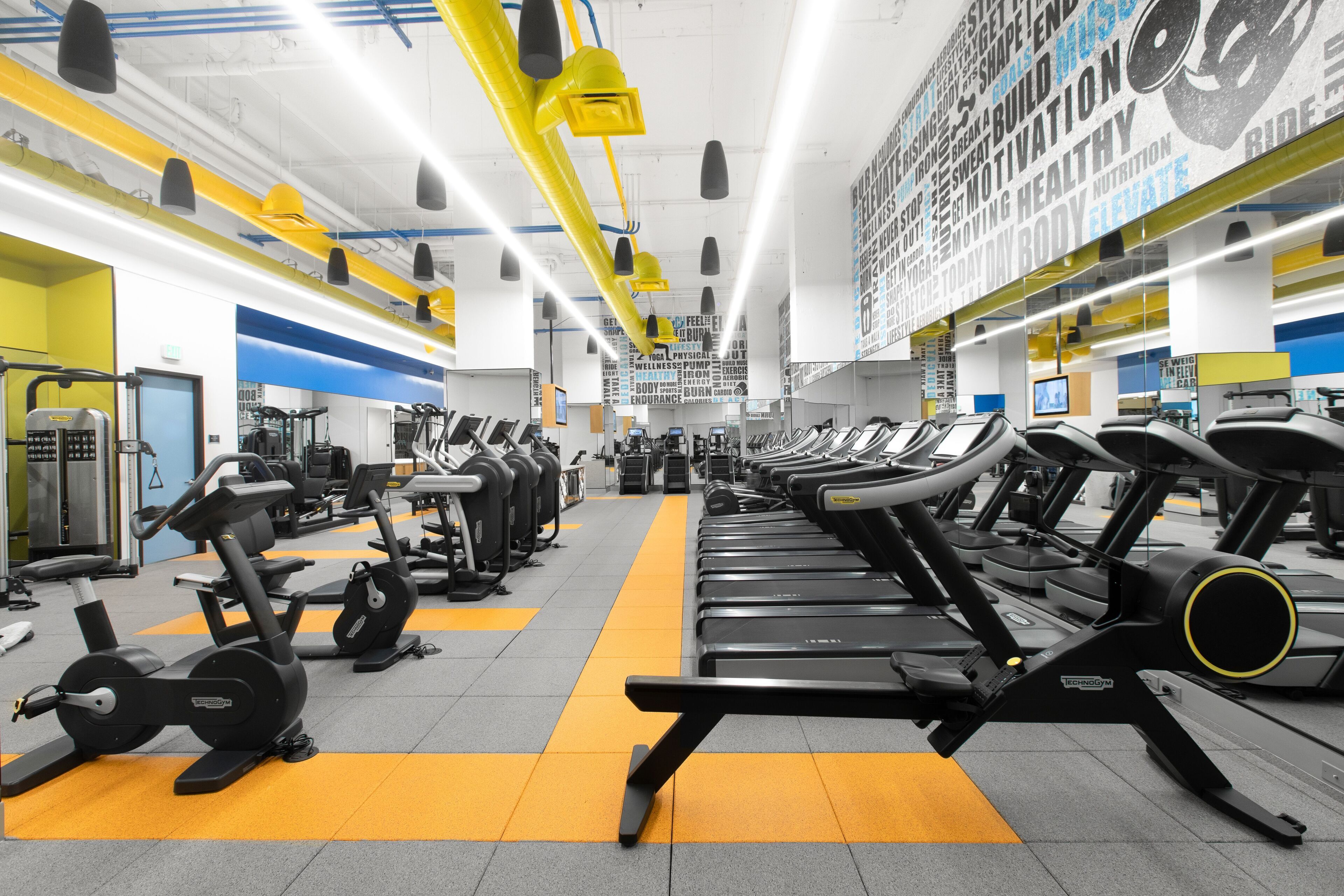 Une salle de sport équipée de tapis de course, de vélos d’appartement et d’appareils de musculation.