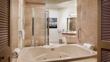 Un baño moderno con una bañera grande, una ducha con cerramiento de vidrio y un tocador con espejo.