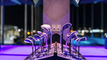 Una exhibición de palos de golf sobre un soporte con un fondo iluminado en morado.