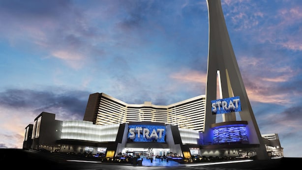 Un hôtel doté d’une tour imposante et dont la façade est illuminée par le nom « STRAT ».