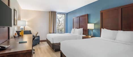 Cubrecamas, escritorio y espacio para trabajar con laptop