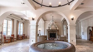 Un intérieur spacieux agrémenté d’une fontaine centrale, de voûtes et d’une cheminée.