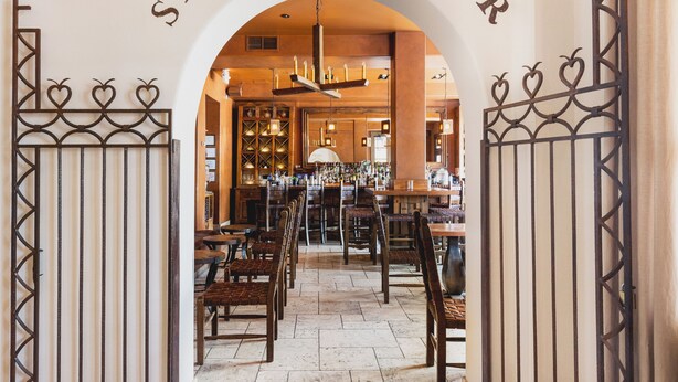 L’entrée d’un bar, avec une enseigne indiquant « SECRETO BAR » au-dessus de la porte.